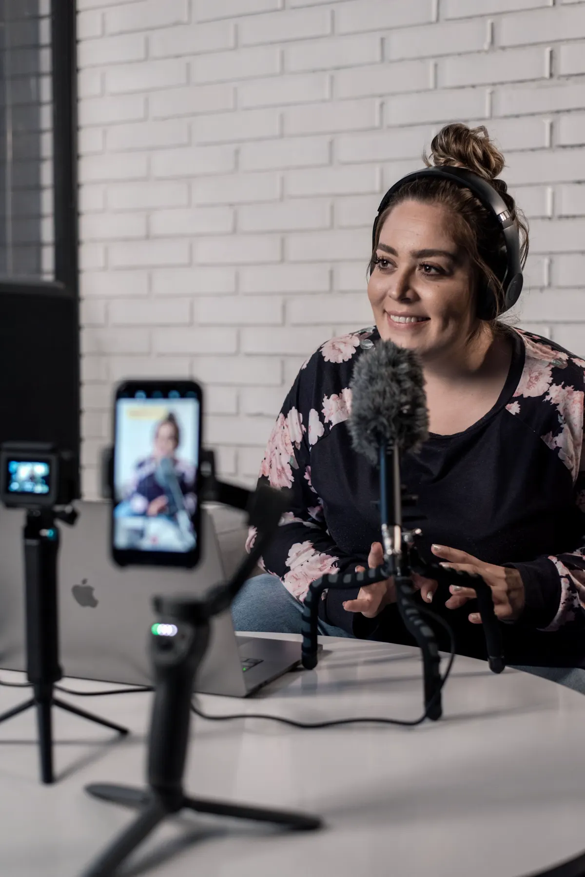 Especialista gravando um vídeo com celular, microfone e notebook
